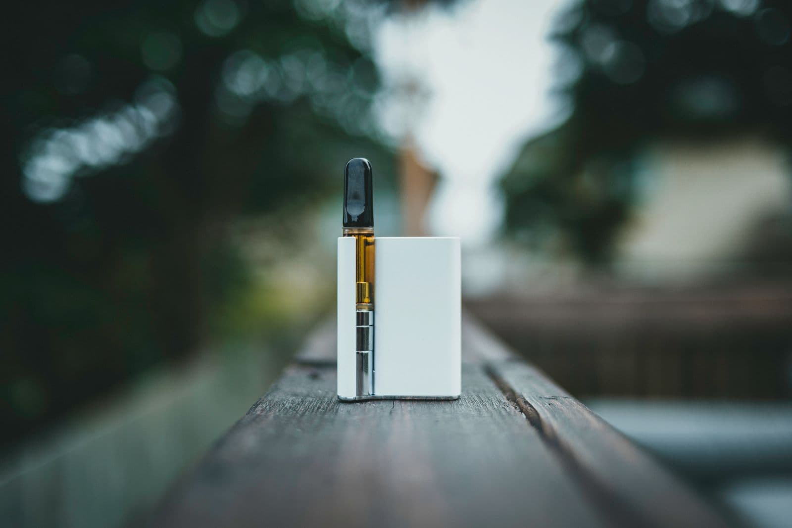 A white pod device resting on a wooden surface